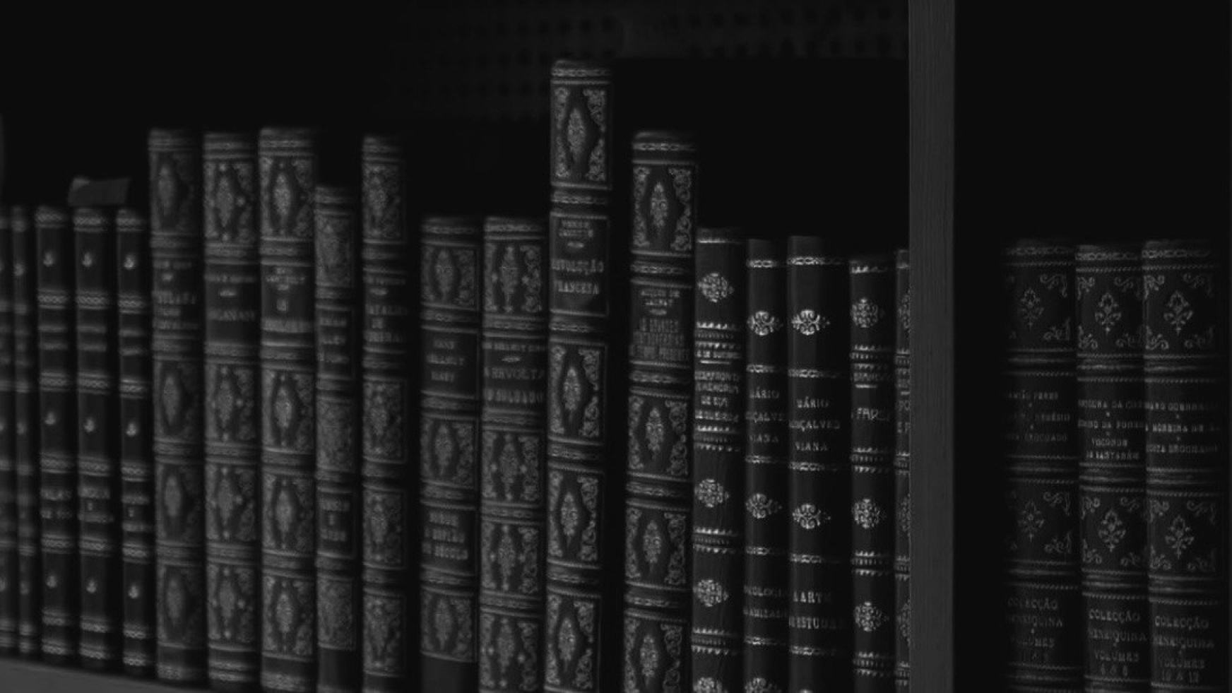 Чёрно-белая книжная полка с классическими изданиями в тёмных переплётах